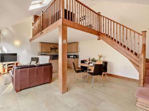 a living room with a staircase and a table and chairs at 1 Bed in Doncaster oc-91308 in Mattersey +8 photos