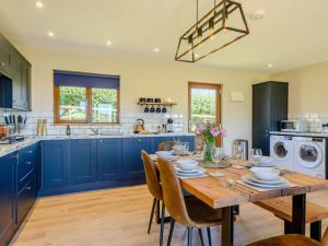 a kitchen with blue cabinets and a wooden table with chairs at 2 Bed in Llandrindod Wells oc-89064 in Nantmel