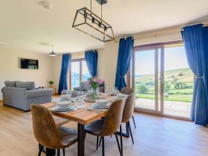 a dining room with a table and chairs and blue curtains at 2 Bed in Llandrindod Wells oc-89064 in Nantmel