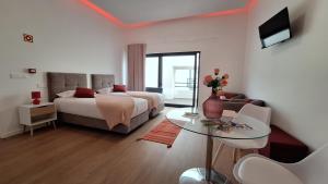 a bedroom with a bed and a table and a tv at AzoreanStar Accommodations in Ponta Delgada