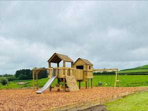 a wooden playground with a slide and a house at 1 Bed in Rhayader oc-90278 in Saint Harmon +13 photos