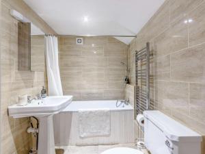 a bathroom with a sink and a tub and a toilet at 3 Bed in Chippenham oc-77334 in Chippenham
