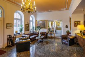 a living room with leather furniture and a chandelier at Hotel Fürstenhof in Rathenow