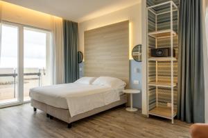 a bedroom with a bed and a large window at Hotel Baia in Rimini +41 photos