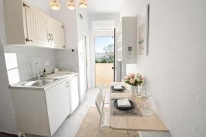 a kitchen with a table with chairs and a sink at Ameli Studio ,Balcony with Mountain View, Kitchenette, 1km to Beach by likeyourhome in Corfu