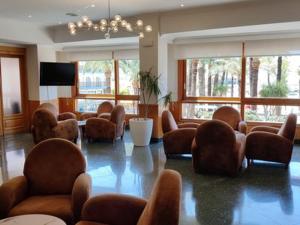 a lobby with a waiting room with chairs and a television at Hotel Tanit in Benidorm