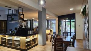 eine Küche und ein Esszimmer mit einem Tisch und einer Bar in der Unterkunft Hotel Alf in Borovany