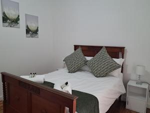 a bedroom with a bed with white sheets and pillows at Eenvoud in Rosendal