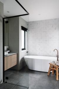 a white bath tub in a bathroom with a sink at Aspen Lodge Bright in Bright +28 photos
