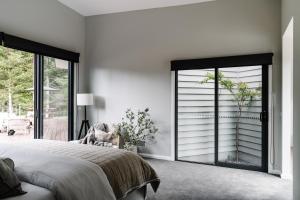 a bedroom with a bed and a sliding glass door at Aspen Lodge Bright in Bright
