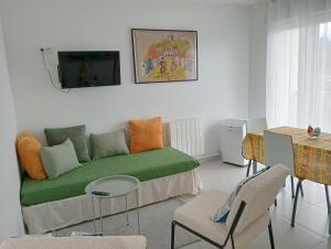 a living room with a green couch and a table at Casa Coruja in Ponte da Barca