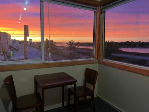 a table and two chairs in a room with a window at Railway Hotel Greymouth in Greymouth