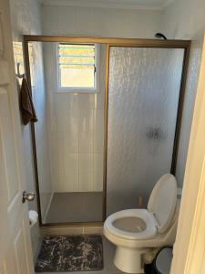 a small bathroom with a toilet and a shower at Katarina Logde en la naturaleza in Tongoicillo