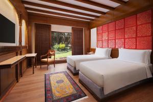 two beds in a room with a television and a piano at The Soaltee Kathmandu, Autograph Collection in Kathmandu +50 photos