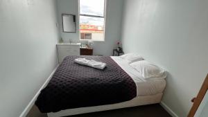 a bedroom with a bed with two shoes on it at Railway Hotel Greymouth in Greymouth +29 photos