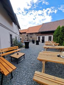 a row of wooden benches sitting next to a building at Penzion U Švarců in Zduchovice