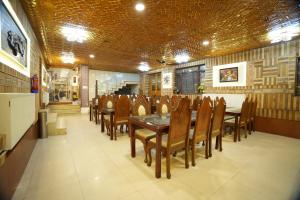 a dining room with a table and wooden chairs at Hotel Park Plaza Srinagar in Srinagar
