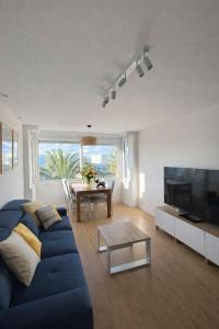 a living room with a blue couch and a table at AriaSpot Alicante in Gran Alacant