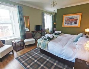 a bedroom with a large bed and a living room at The Glenerne in Eyemouth