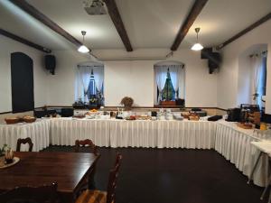 a group of tables in a room with white table cloth at Penzion U Švarců in Zduchovice
