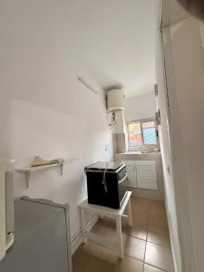 a small white kitchen with a table and a window at Residence Mamie Léo in Abidjan