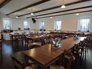 a dining room with wooden tables and chairs at Penzion U Švarců in Zduchovice