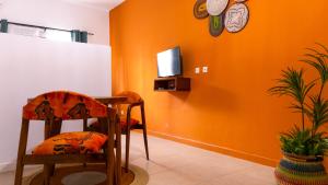 a room with a table and two chairs and a clock at Residence Mamie Léo in Abidjan +10 photos