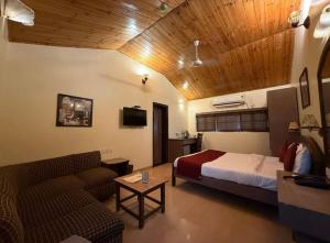 a bedroom with a bed and a couch in a room at Hotel Beach Garden in Mumbai