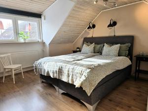 a bedroom with a large bed and two windows at Apartment Norrgården in Genevad