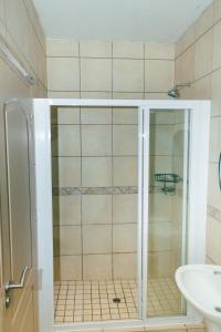 a shower with a glass door in a bathroom at The Prestige Studio in Bloemfontein +15 photos