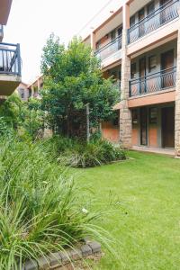 a building with a grass yard in front of a building at The Prestige Studio in Bloemfontein
