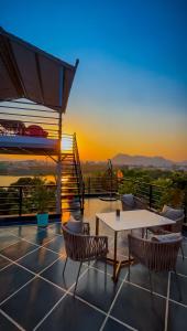 a patio with a table and chairs and the sunset at Saga by Lake in Udaipur
