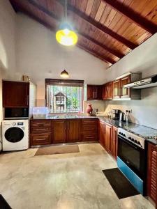 a large kitchen with wooden cabinets and a window at Colonial Boutique Villa Kandy in Kandy
