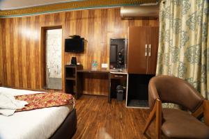 a hotel room with a bed and a desk and a television at Hotel Park Plaza Srinagar in Srinagar