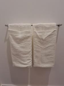 two white towels hanging on a towel rack in a bathroom at AzoreanStar Accommodations in Ponta Delgada +129 photos