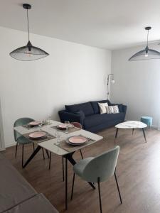 a living room with a table and a couch at Elégance du Golfe in Vallauris