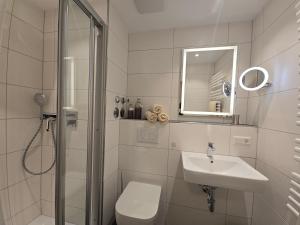 a bathroom with a shower and a toilet and a sink at Herzmuschel in Norderney +8 photos
