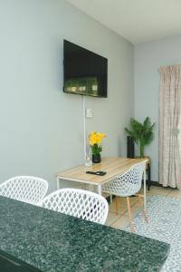 a dining room with a table and chairs and a television at The Prestige Studio in Bloemfontein