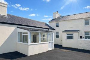 an extension to a white house with a garage at The Croft in Ramsey