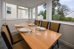 a wooden table with chairs and wine glasses on it at The Croft in Ramsey