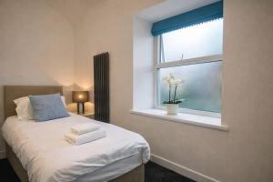 a bedroom with a bed and a window at The Croft in Ramsey