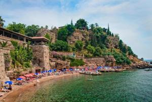 a beach with umbrellas and people in the water at Moon City in Antalya