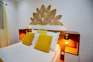 a bedroom with a large bed with yellow pillows at Tranokely II in Antananarivo