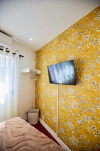 a bedroom with a tv on a yellow wall at Tranokely II in Antananarivo