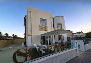 ein Gebäude mit einem Restaurant mit Sonnenschirm und Tisch in der Unterkunft Glorian Hotel in Pula
