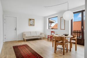 a white living room with a table and chairs at God Plads Og God Beliggenhed I Løkkenshus in Løkken