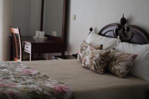 una camera da letto con un letto con cuscini e una scrivania di Hotel Peninsular- Porto a Porto
