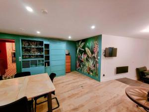 a dining room with a table and a tv on a wall at Milliaux - Bail Partner in Auxerre