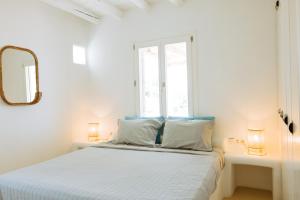 a white bedroom with a bed and a window at Villa Riza in Apróvaton +38 photos