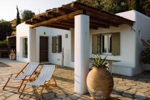 two chairs and a table in front of a house at Villa Riza in Apróvaton